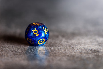 Blue Astrology Dice with symbol of the planet Mercury on grey background