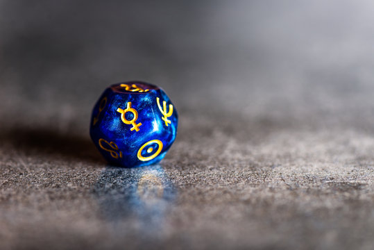 Blue Astrology Dice with symbol of the planet Mercury on grey background