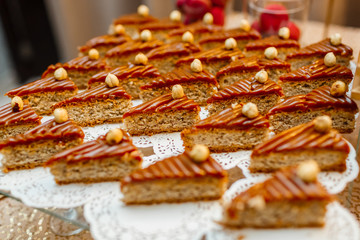 Table with sweets and goodies for the wedding party reception, decorated dessert table. Delicious sweets on candy buffet. Dessert table for a party. cakes, cupcakes.