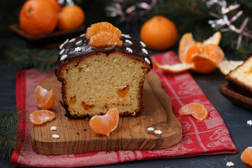 Cupcake with tangerines, covered with chocolate glaze is located on the New Year's background, Festive still life