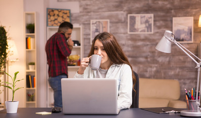 Caucasian female freelancer working on laptop in living room