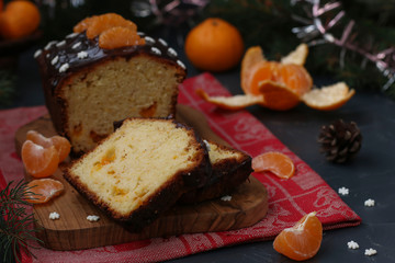 Cupcake with tangerines, covered with chocolate glaze is located on the New Year's background, Festive still life