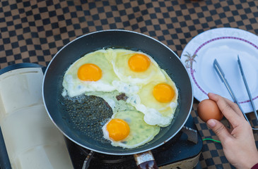 Cropped Hand Of Woman Fried Egg in Pan