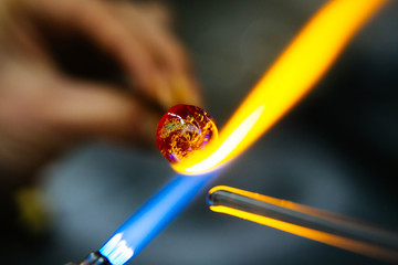 Close-up of glass bead melting in gas-burner fire