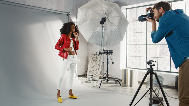 Behind the Scenes on Photo Shoot: Beautiful Black Model Poses for a Photographer, he Takes Photos with Professional Camera. Stylish Fashion Magazine Photoshoot done with Pro Equipment in a Studio.