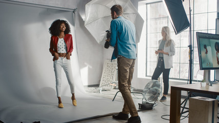 Beautiful Black Model Posing for a Photographer, he Takes Pictures with Professional Camera. Stylish Fashion Magazine Photoshoot done with Pro Equipment in a Studio.