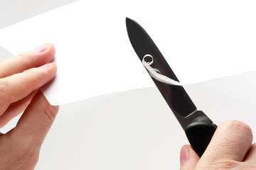  blade of a sharp knife cut across the white paper