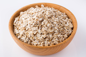 raw oat flakes on white acrylic background