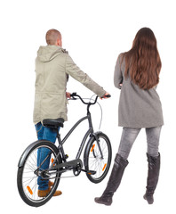 Back view of couple in winter jacket. man on a bicycle and a woman.
