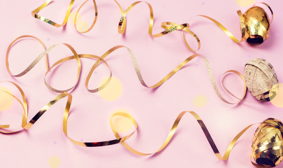 Obraz premium Three Bright Golden Gift Ribbons on Pink Background Holidays Festive Flat Lay Top View Minimal Concept Serpantine Horizontal Toned