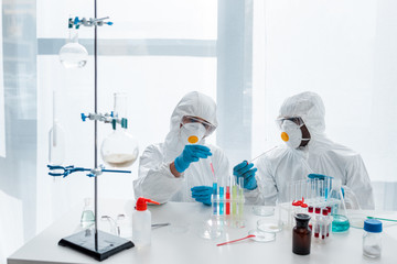 multicultural scientists in protective suits doing dna test in lab