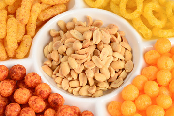 Mix of snacks on a white plate isolated on white.