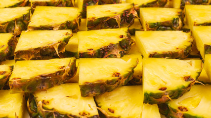 Pineapple juicy yellow slices background. Top view.