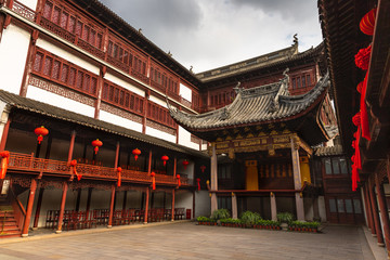 Fototapeta na wymiar Beautiful, traditional building with red lanterns in Yu Garden, Shanghai, China, under a moody, cloudy sky