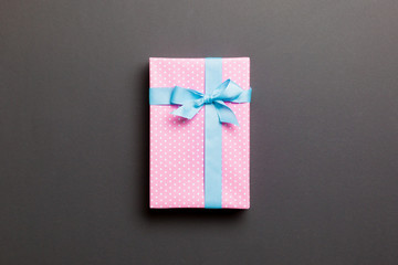 Top view Christmas present box with blue bow on black background with copy space