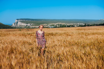 a woman farmer in field of wheat before the harvest