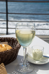 Summer holiday on sea, drinking white wine on outdoor terrace with sea view in sunny day
