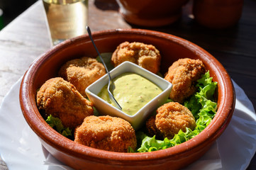 Fried whole champignons muchrooms with bread crumbs served with dip sauce