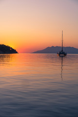 Scenic beautiful sunrise with a view on a boat at the marine of Epidaurus Island, Peloponnese, Saronic Gulf, Greece. 