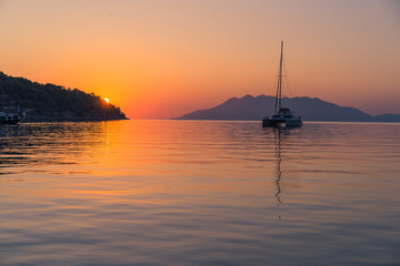 Scenic beautiful sunrise with a view on a boat at the marine of Epidaurus Island, Peloponnese, Saronic Gulf, Greece. 