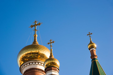 Fototapeta na wymiar Three domes of the Orthodox Church against the blue sky. Religious architecture