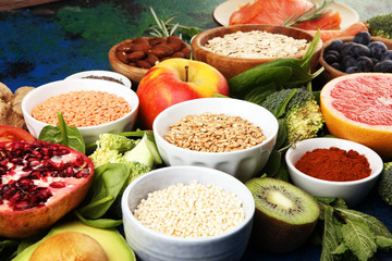 Healthy food clean eating selection: fish, fruit, vegetable, cereal, leaf vegetable on rustic background