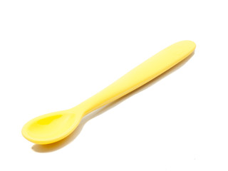Yellow silicone baby spoon on white background