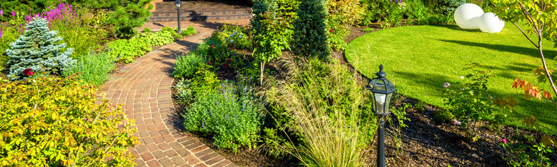 Landscape design in home garden, landscaping in backyard of residential house.