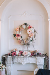 Wedding decorations made of paper flowers in a studio against a white wall. Details, accessories. Photography, concept.