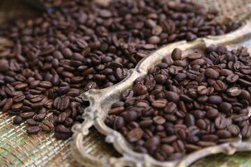 Coffee in special roasting grains and shapes on the table and on the gold color tray