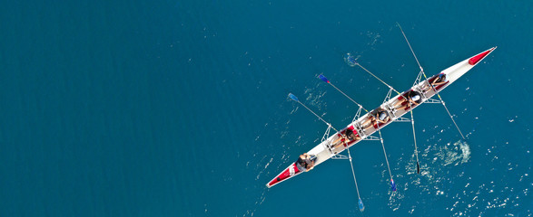 Aerial drone ultra wide photo with copy space of sport canoe with young team of athletes practising...