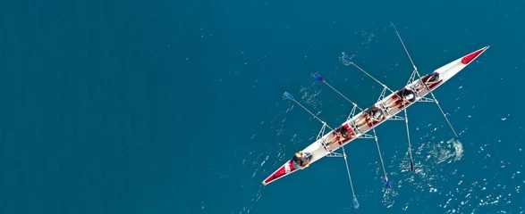 Küchenrückwand glas motiv Aerial drone ultra wide photo with copy space of sport canoe with young team of athletes practising in deep blue open ocean sea © aerial-drone
