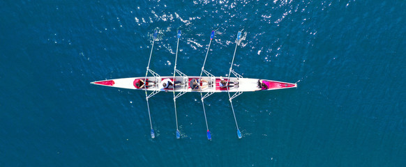 Aerial drone ultra wide photo of sport canoe with young team of athletes practising in deep blue...