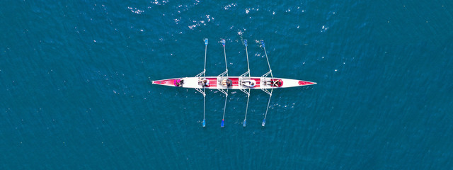 Aerial drone ultra wide photo of sport canoe with young team of athletes practising in deep blue open ocean sea