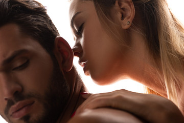 close up of seductive woman kissing handsome man, isolated on white