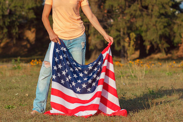 Woman with a flag of United States of America in the hand, outdoors