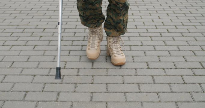 Front view of wounded soldier with crutch.