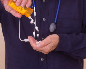 Medical doctor is pouring a large amount of prescribed drugs showing over prescribing a...