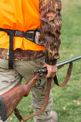 Hunting period, autumn season open. A hunter with a gun in his hands in hunting clothes in the...