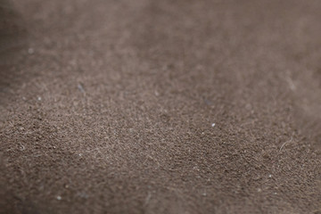 Close-up photograph of brown suede surface, texture