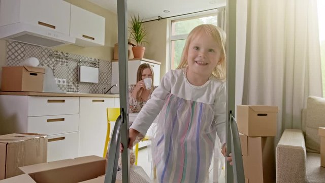 Active Family Group Move in Rent Real Estate. Positive Looking at Relocating or Unpacking of Carton Pack by Playful Family. ittle girl climbs the stairs and looks at the camera. Enjoying Life