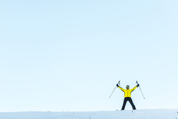 Naklejka na ściany i meble skier in helmet holding sticks while standing on snow