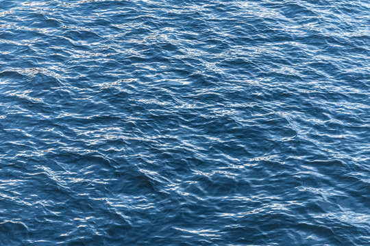 Blue water surface. Background texture photo of a water, river or sea. Clear wawing water surface.