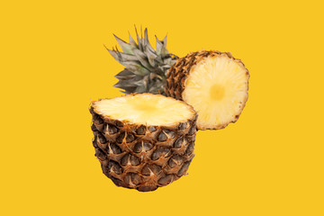 Pineapple half. Cut pineapple isolated on yellow. Pineapple with leaves