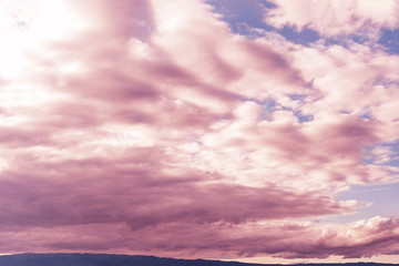 Romantic sunset sky background. Sunset light colors clouds in red, orange, pink and purple.