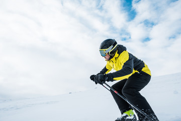 sportsman in helmet skiing on slope in wintertime