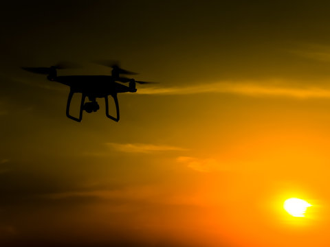 Quadrocopters silhouette against the background of the sunset. F