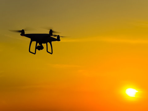 Quadrocopters silhouette against the background of the sunset. F
