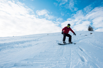 Fototapeta na wymiar athletic snowboarder riding on slope in winter