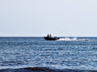 The boat rushes by the sea. In the boat people. Seascape in the
